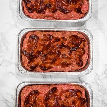 meatloaf mix with barbecue sauce topping in foil loaf pans