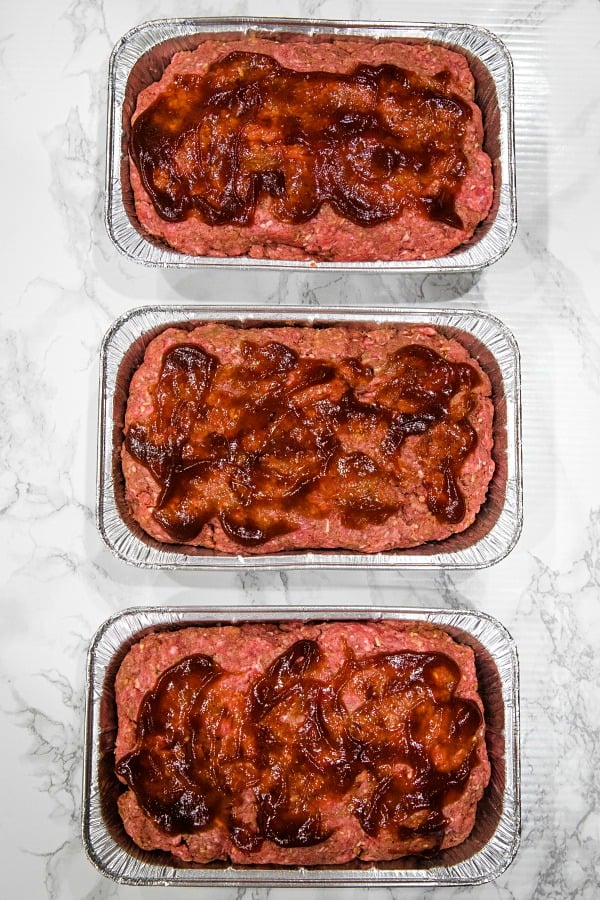 meatloaf mix with barbecue sauce topping in foil loaf pans