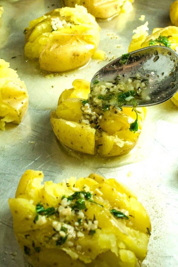 Spooning herb butter over boiled potatoes