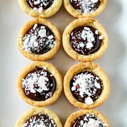 Chocolate Peppermint Sugar Cookie Cups - Tender sugar cookie cups brimming with chocolate ganache filling and crushed peppermint sprinkles! Three holiday favorites in one delicious treat!