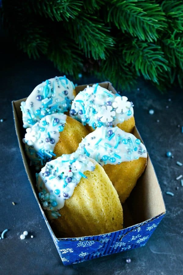 Easy Holiday Madeleines - French butter cookie cakes that are golden crisp on the outside and soft and spongy in the middle. These teacakes, dipped in white chocolate and decorated for the holidays, are surprisingly easy to make with the most basic ingredients. 