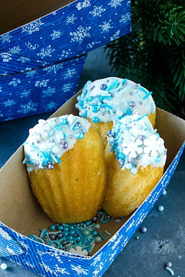 Easy Holiday Madeleines - French butter cookie cakes that are golden crisp on the outside and soft and spongy in the middle. These teacakes, dipped in white chocolate and decorated for the holidays, are surprisingly easy to make with the most basic ingredients.