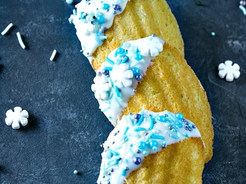 Easy Holiday Madeleines - French butter cookie cakes that are golden crisp on the outside and soft and spongy in the middle. These teacakes, dipped in white chocolate and decorated for the holidays, are surprisingly easy to make with the most basic ingredients.