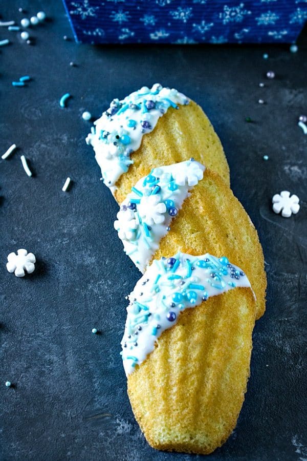 Easy Holiday Madeleines - French butter cookie cakes that are golden crisp on the outside and soft and spongy in the middle. These teacakes, dipped in white chocolate and decorated for the holidays, are surprisingly easy to make with the most basic ingredients.