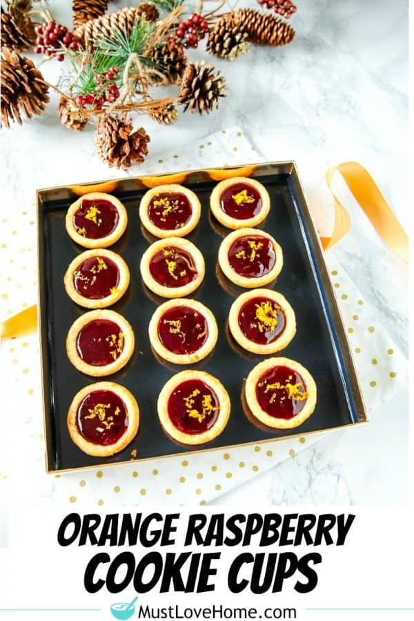 Orange Raspberry Cookie Cups - Buttery orange flavored sugar cookie cups filled with raspberry jam and sprinkled with fresh orange zest. Festive on the cookie tray and easy on the budget.