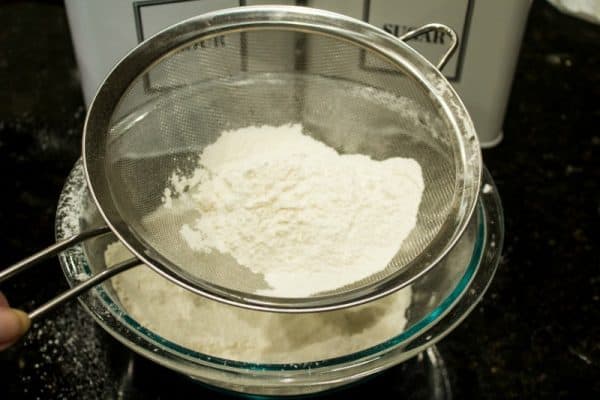 Sifting dry ingredients for Raspberry Pecan Swirl Cookies