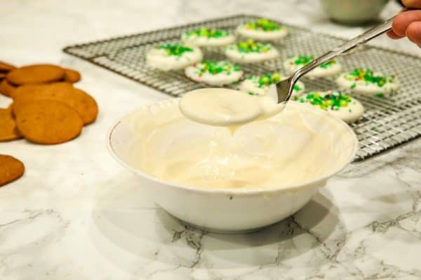 Coating gingerbread crisps with white chocolate.