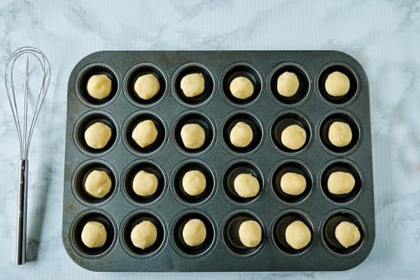 rolled sugar cookie dough in mini muffin pans