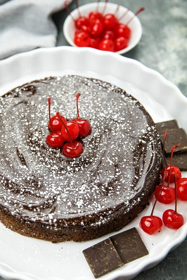 This decadent, gluten-free  Flourless Chocolate Cake with Dried Cherries is for serious chocolate lovers. With only 8 ingredients, including bittersweet chocolate and cocoa powder, it's irresistibly delicious.#mustlovehomecooking