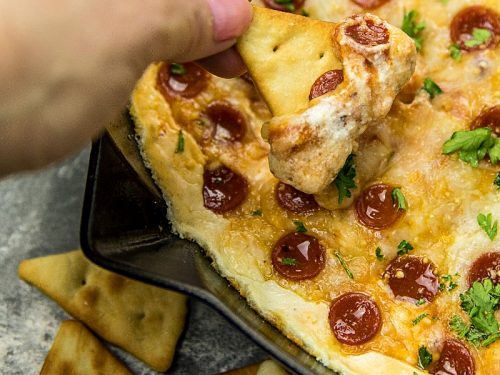 Pepperoni Pizza dip recipe is creamy, cheesy, loaded with spicy pepperoni and totally crave worthy! Serve your pizza dip with pita chips for the ultimate party snack. #mustlovehomecooking