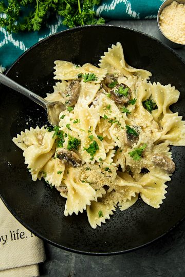 Creamy Mushroom Farfalle Pasta is a simple, easy to make meatless Italian dinner of mushrooms, scallions and seasonings tossed with noodles in a creamy parmesan sauce.#mustlovehomecooking