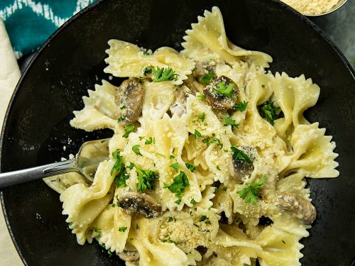 Creamy Mushroom Farfalle Pasta is a simple, easy to make meatless Italian dinner of mushrooms, scallions and seasonings tossed with noodles in a creamy parmesan sauce. #mustlovehomecooking
