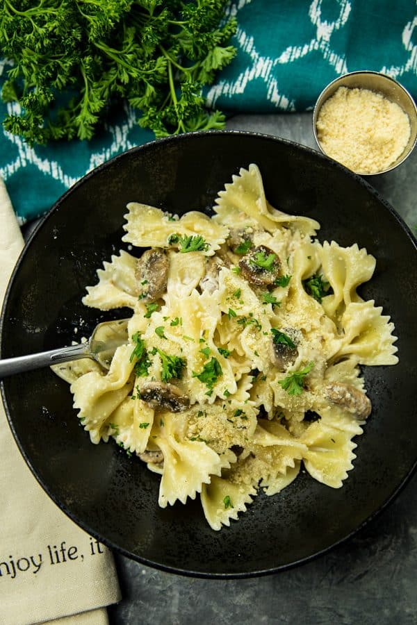 Creamy Mushroom Farfalle Pasta is a simple, easy to make meatless Italian dinner of mushrooms, scallions and seasonings tossed with noodles in a creamy parmesan sauce. #mustlovehomecooking