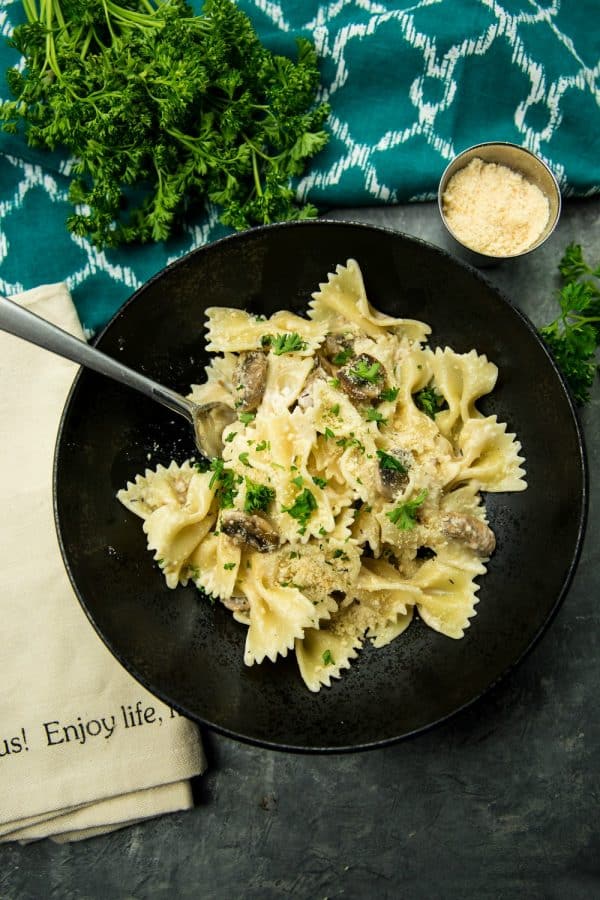 Creamy Mushroom Farfalle Pasta is a simple, easy to make meatless Italian dinner of mushrooms, scallions and seasonings tossed with noodles in a creamy parmesan sauce. #mustlovehomecooking