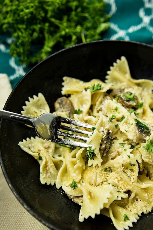 Creamy Mushroom Farfalle Pasta is a simple, easy to make meatless Italian dinner of mushrooms, scallions and seasonings tossed with noodles in a creamy parmesan sauce. #mustlovehomecooking