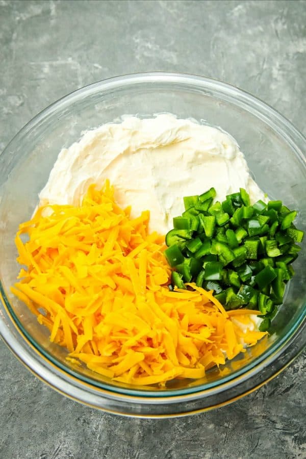 Ingredients for popper dip in glass mixing bowl