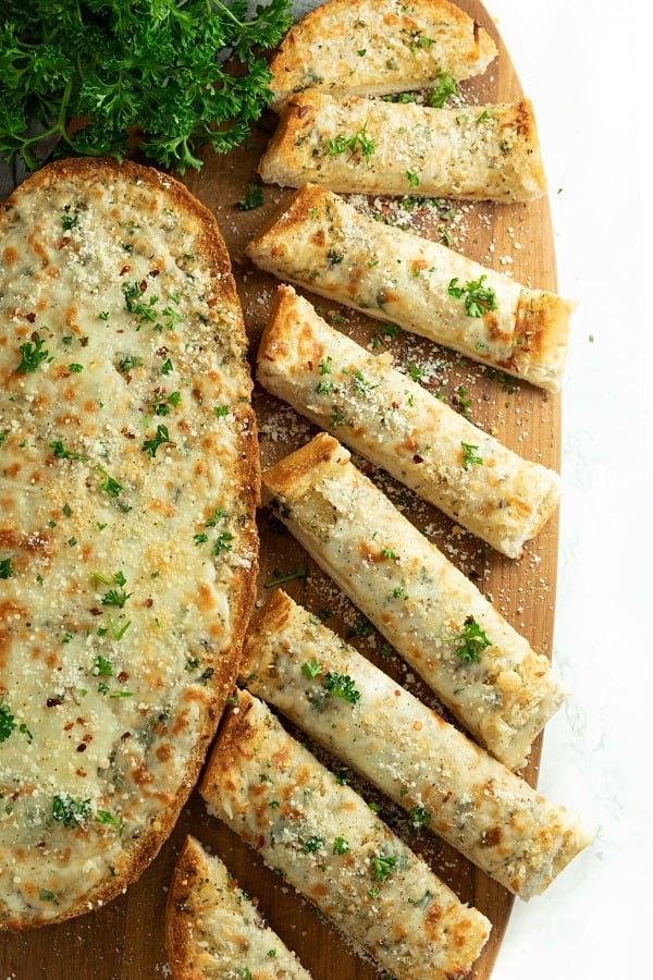 This is the BEST Cheesy Garlic Bread! One bite of this cheesy gooey bread will have eveyone begging for it again and again! #mustlovehomecooking #garlicbread