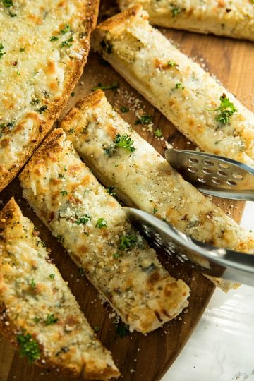 This is the BEST Cheesy Garlic Bread! One bite of this cheesy gooey bread will have eveyone begging for it again and again! #mustlovehomecooking #garlicbread