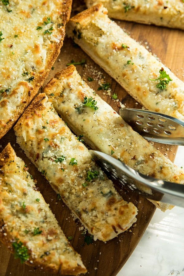 This is the BEST Cheesy Garlic Bread! One bite of this cheesy gooey bread will have eveyone begging for it again and again! #mustlovehomecooking #garlicbread