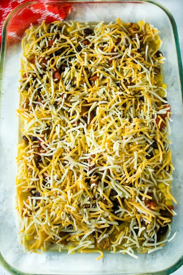 Chicken Taco Casserole is sauce coated tortillas, a zesty mix of chicken, beans, chilies and seasoning, topped with a thick layer of melted cheese. Boldly flavored and simple to make.#mustlovehomecooking #casserole #mexicanfood