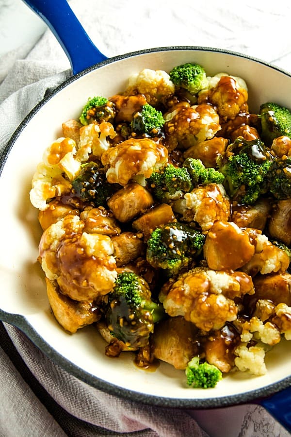 The BEST simple Orange Garlic Chicken Stir Fry you'll ever make. Chunks of chicken, healthy broccoli and cauliflower coated in a easy sweet and savory sauce. #mustlovehomecooking #stirfry