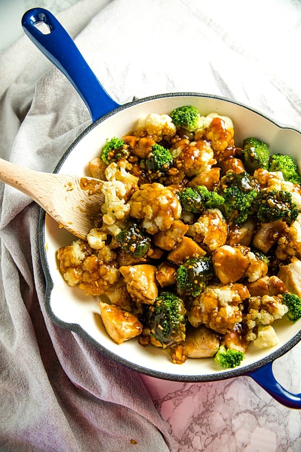 The BEST simple Orange Garlic Chicken Stir Fry you'll ever make. Chunks of chicken, healthy broccoli and cauliflower coated in a easy sweet and savory sauce. #mustlovehomecooking #stirfry