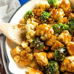 The BEST simple Orange Garlic Chicken Stir Fry you'll ever make. Chunks of chicken, healthy broccoli and cauliflower coated in a easy sweet and savory sauce. #mustlovehomecooking #stirfry