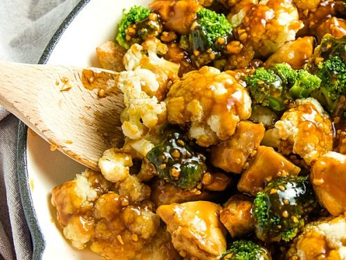 The BEST simple Orange Garlic Chicken Stir Fry you'll ever make. Chunks of chicken, healthy broccoli and cauliflower coated in a easy sweet and savory sauce. #mustlovehomecooking #stirfry