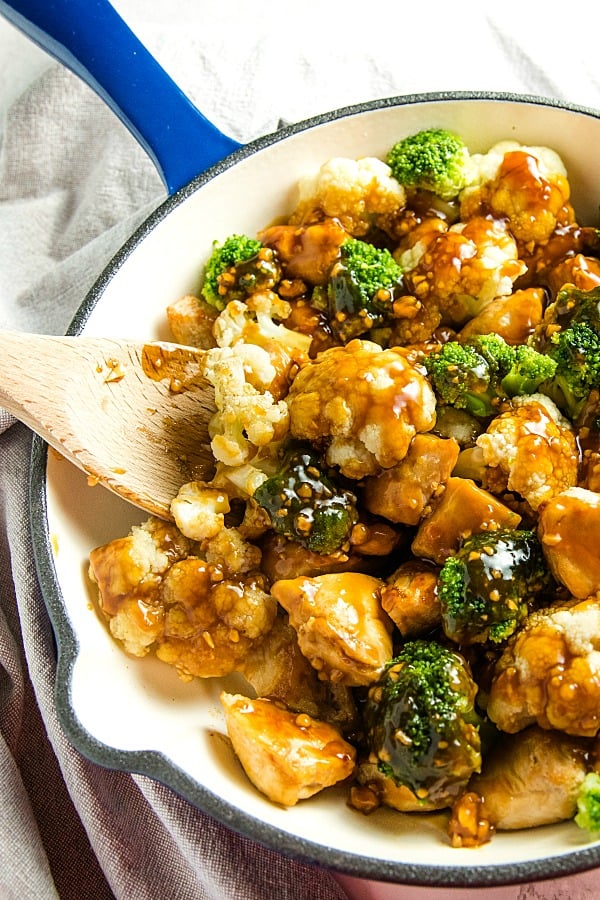 The BEST simple Orange Garlic Chicken Stir Fry you'll ever make. Chunks of chicken, healthy broccoli and cauliflower coated in a easy sweet and savory sauce. #mustlovehomecooking #stirfry