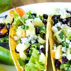 Easy Oven Chicken Tacos are seasoned shredded chicken stuffed into refried bean smeared crunchy shells and topped with cheese. Baked easy in the oven then loaded with spoonfuls of fresh pineapple salsa. #mustlovehomecooing #chickentacos #mexicanfood