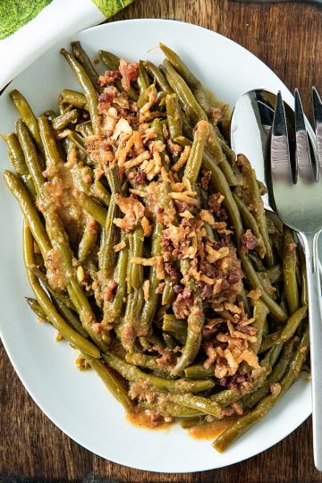 Super tender, loaded with flavor Southern-style green bean recipe with bacon, crispy onions and lots of seasonings. #mustlovehomecooking #slowcookerrecipes #greenbeanrecipe