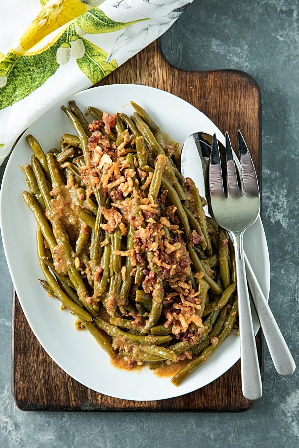 Super tender, loaded with flavor Southern-style green bean recipe with bacon, crispy onions and lots of seasonings. #mustlovehomecooking #slowcookerrecipes #greenbeanrecipe