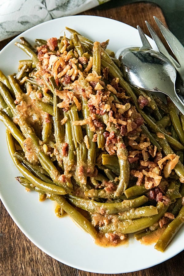 Super tender, loaded with flavor Southern-style green bean recipe with bacon, crispy onions and lots of seasonings. #mustlovehomecooking #slowcookerrecipes #greenbeanrecipe