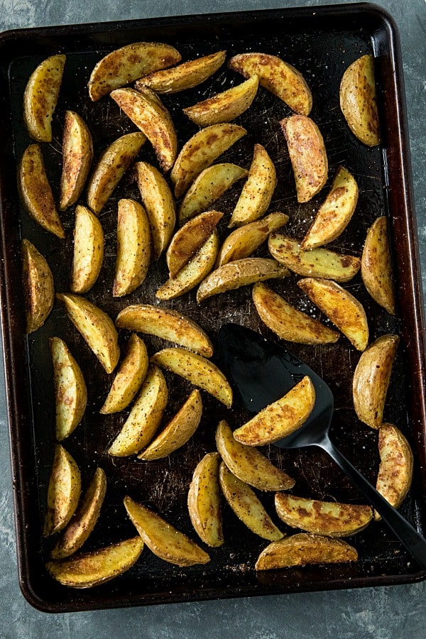 Crispy Roasted Potato Wedges - easy oven baked golden brown potatoes with olive oil, garlic and parmesan cheese. #mustlovehomecooking #ovenpotatorecipes