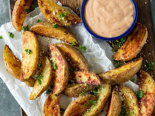 Crispy Roasted Potato Wedges - easy oven baked golden brown potatoes with olive oil, garlic and parmesan cheese. #mustlovehomecooking #ovenpotatorecipes