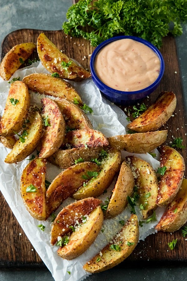 Crispy Roasted Potato Wedges - easy oven baked golden brown potatoes with olive oil, garlic and parmesan cheese. #mustlovehomecooking #ovenpotatorecipes