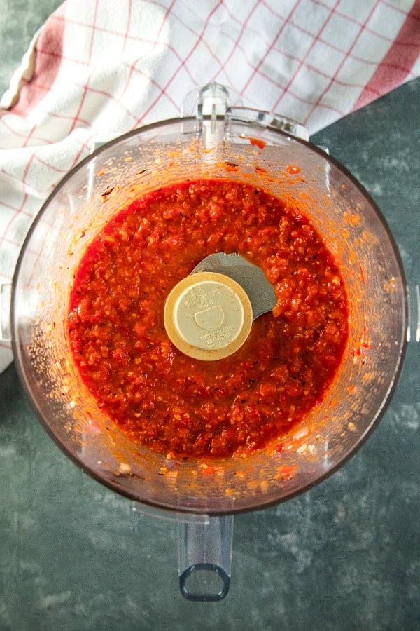Puree of roasted red pepper sauce ingredients in bowl of food processor