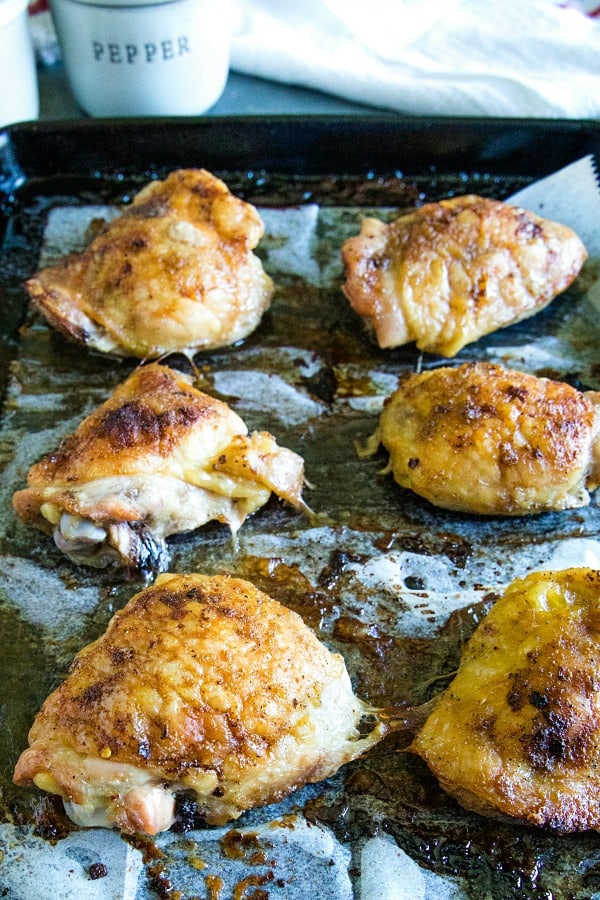 Roasted chicken thighs on baking sheet with parchments paper
