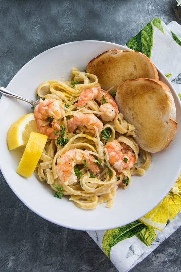 Lemon Pepper Shrimp Alfredo made with lemony seasoned shrimp, fettuccine and an addictive cheesy cream sauce. A busy weeknight favorite! #mustlovehomecooking