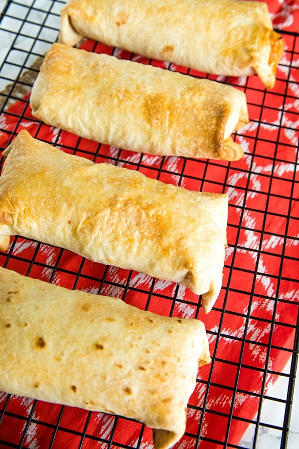 Golden baked Chimichangas on wire rack