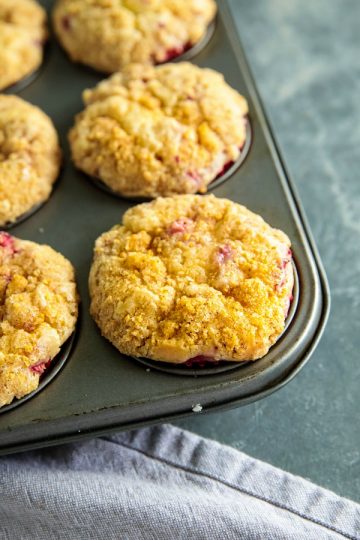 Strawberry Cheesecake Muffins are studded with fresh strawberries, have a luscious swirl of cheesecake in the middle and are topped with a thick layer of buttery streusel. Life changing! #mustlovehomecooking