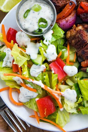 a fresh and healthy side salad made with romaine lettuce greens, garden vegetables and sunflower seeds then drizzled with a tangy homemade herb dressing.