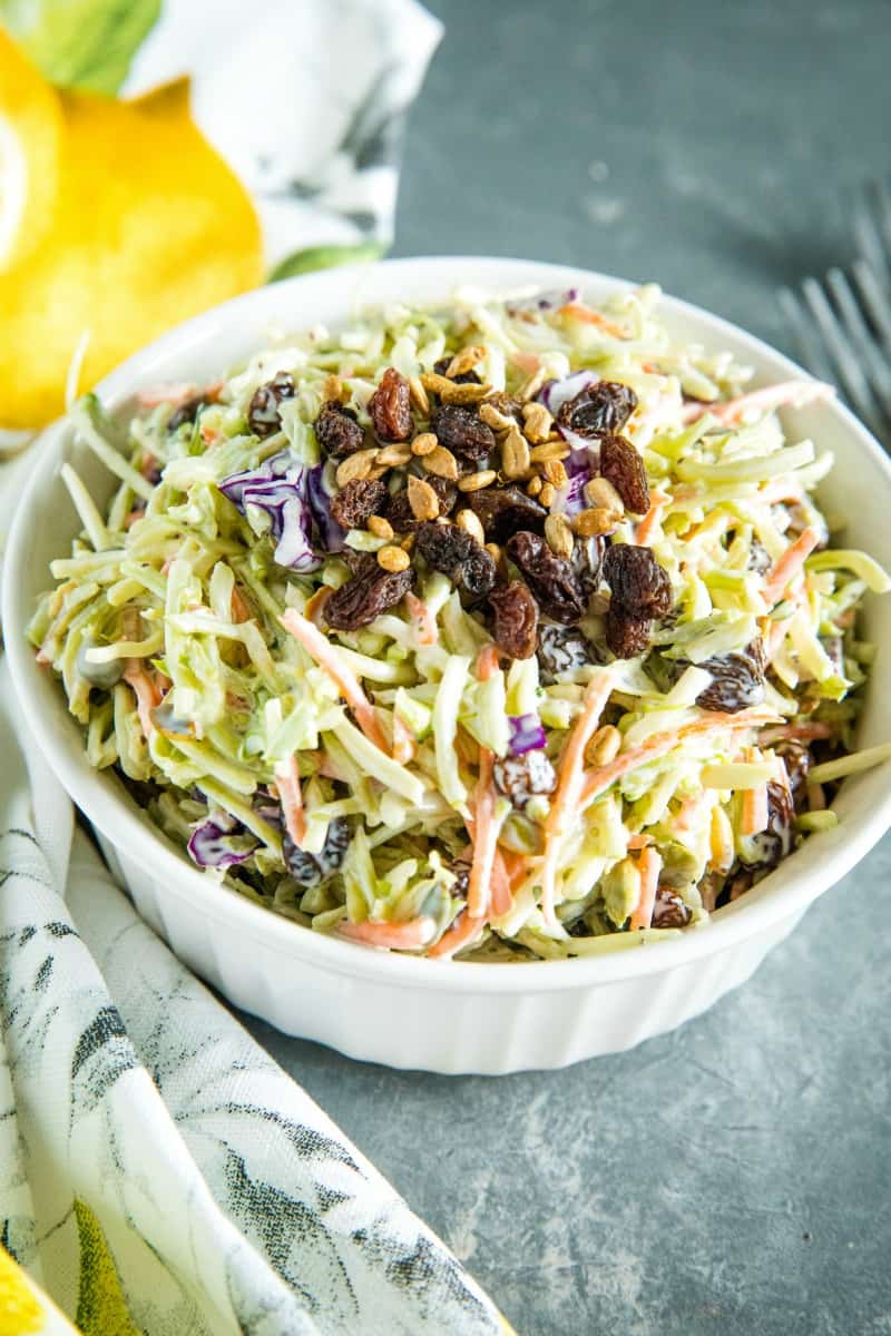 Easy Broccoli Slaw is a healthy, crunchy and sugar free blend of shredded broccoli, raisins and pepitas with an irresistible sweet and sour dressing. #mustlovehomecooking