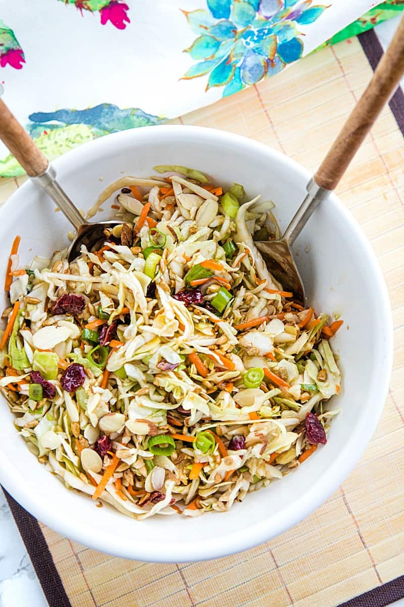 Midwest Cabbage Salad is a cold and crisp side dish made with shredded cabbage, green onions, dried cranberries, almonds. sunflower seeds and sweet dressing is fresh, healthy and stays crunchy in the refrigerator for several days! #mustlovehomecooking