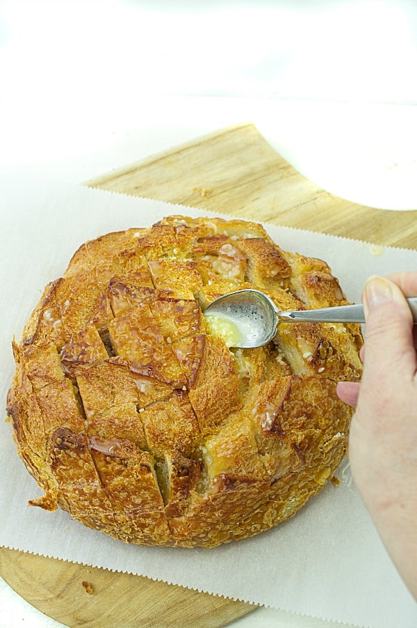 Pull apart three cheese garlic bread is a round sourdough loaf drizzled with garlic butter and stuffed with melting cheese. Crusty, and gooey hot bread made easy in under 30 minutes. #mustlovehomecooking