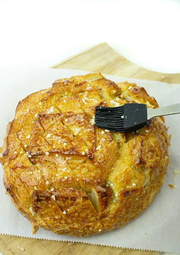 Pull apart three cheese garlic bread is a round sourdough loaf drizzled with garlic butter and stuffed with melting cheese. Crusty, and gooey hot bread made easy in under 30 minutes. #mustlovehomecooking