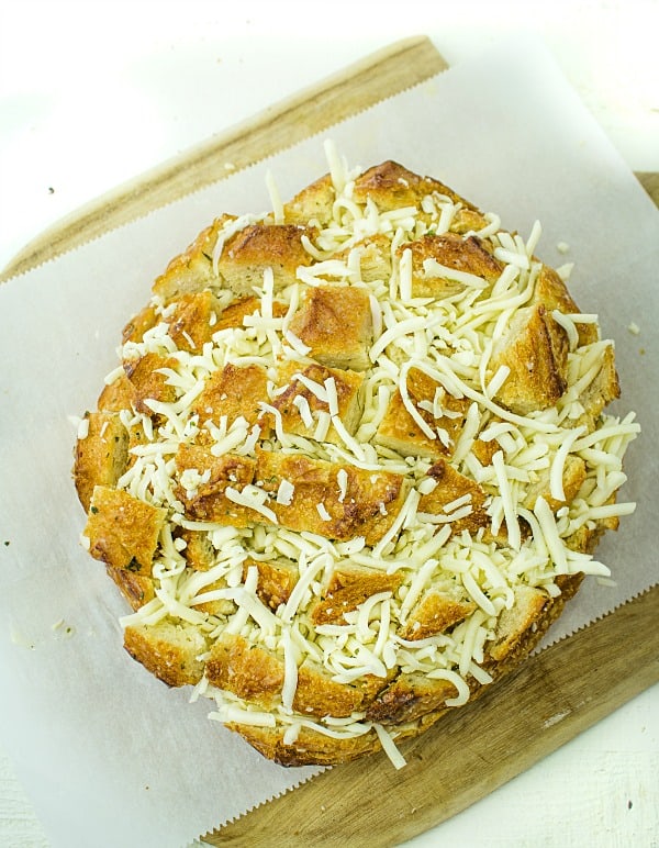 Pull apart three cheese garlic bread is a round sourdough loaf drizzled with garlic butter and stuffed with melting cheese. Crusty, and gooey hot bread made easy in under 30 minutes. #mustlovehomecooking