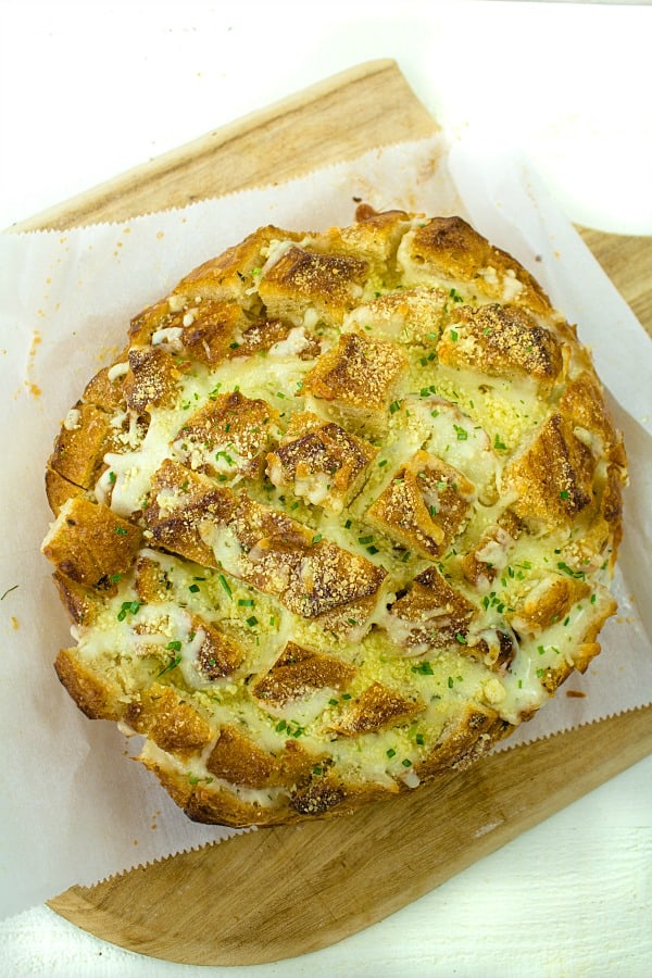 Pull apart three cheese garlic bread is a round sourdough loaf drizzled with garlic butter and stuffed with melting cheese. Crusty, and gooey hot bread made easy in under 30 minutes. #mustlovehomecooking
