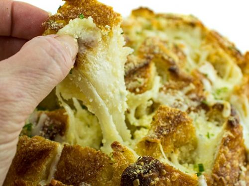 Pull apart three cheese garlic bread is a round sourdough loaf drizzled with garlic butter and stuffed with melting cheese. Crusty, and gooey hot bread made easy in under 30 minutes. #mustlovehomecooking
