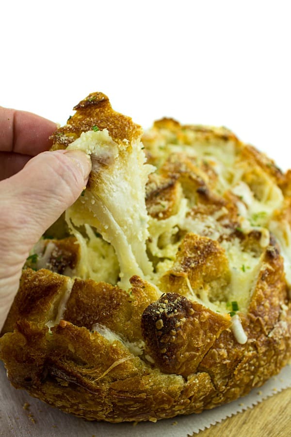 Pull apart three cheese garlic bread is a round sourdough loaf drizzled with garlic butter and stuffed with melting cheese. Crusty, and gooey hot bread made easy in under 30 minutes. #mustlovehomecooking